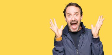 Orta yaş yakışıklı adam deli ve silah ile başarı için hayran kutluyor bir ceket kaldırdı ve açık gözleri çığlık heyecanlı. Kazanan kavramı