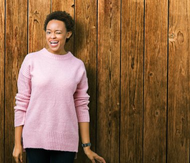 Güzel genç Afro-Amerikan kadın seksi bir ifadeyle, neşeli ve mutlu yüzünü kameraya bakarak göz kırpıyor izole arka plan üzerinde.