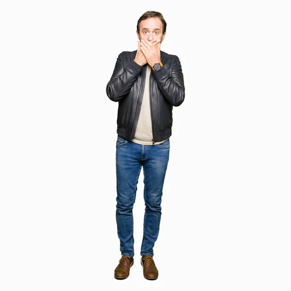 中年のハンサムな男がショックのミスのための手で口を覆っている黒い革のジャケットを身に着けています 秘密の概念 — ストック写真