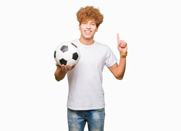 Młody Przystojny Mężczyzna Trzyma Piłkę Nożną Piłki Nożnej Zaskoczony Pomysłem — Zdjęcie stockowe