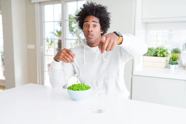 Αφρικανός Αμερικανός Άνθρωπος Τρώγοντας Φρέσκο Πράσινο Αρακά Στο Σπίτι Δείχνοντας — Φωτογραφία Αρχείου