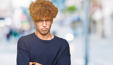 Afro yüz çapraz kolları üzerinde gözlük şüpheci ve sinir, onaylamayan ifade giyen genç yakışıklı adam. Negatif kişi.