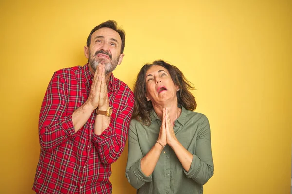 Belo Casal Meia Idade Sobre Fundo Amarelo Isolado Implorando Orando — Fotografia de Stock