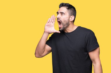 Yakışıklı delikanlı bağırarak ve ağzı üzerinde el ile yan için çığlık izole arka plan üzerinde. İletişim kavramı.