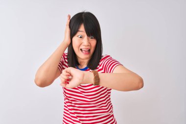 İzole beyaz arka plan üzerinde kırmızı çizgili t-shirt giyen genç güzel Çinli kadın geç almaktan korkuyor, saat zaman endişeli bakıyorum