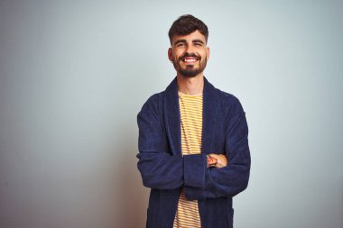 Dövme ile genç adam izole beyaz arka plan üzerinde ayakta bornoz giyiyor kamera bakarak çapraz silah ile gülümseyen yüz. Pozitif kişi.