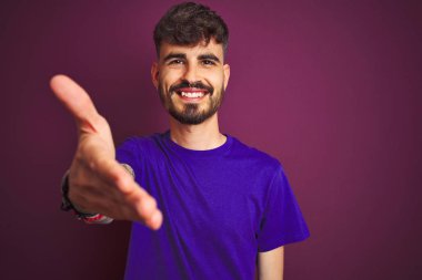 Dövme ile genç adam izole mor arka plan üzerinde ayakta t Başarılı iş.