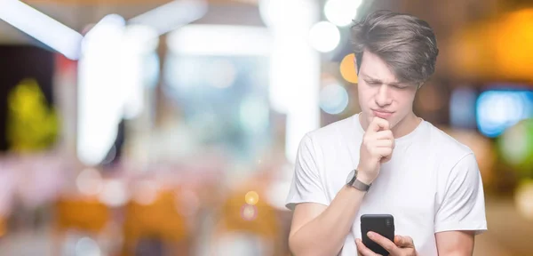 Hombre Joven Usando Teléfono Inteligente Sobre Fondo Aislado Cara Seria —  Fotos de Stock