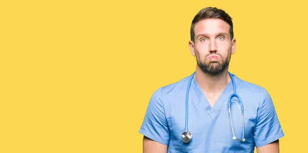 Homem Médico Bonito Vestindo Uniforme Médico Sobre Fundo Isolado Soprando — Fotografia de Stock