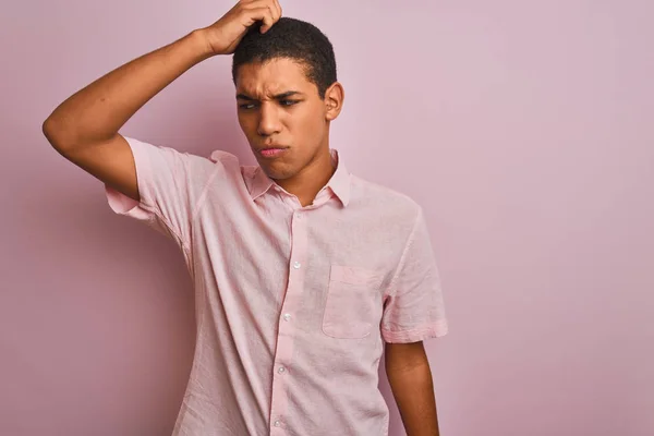 年轻的英俊阿拉伯男子穿着休闲衬衫站在孤立的粉红色背景混淆和怀疑的问题 不确定与怀疑 用手在头上思考 沉思概念 — 图库照片
