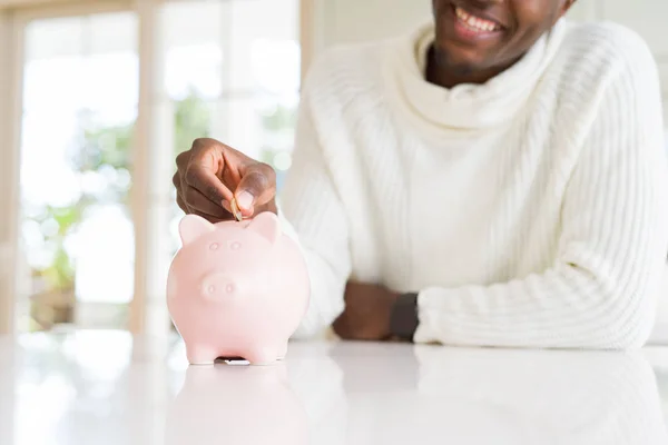 Knappe Jonge Afrikaanse Man Brengen Een Munt Binnen Het Spaarvarken — Stockfoto