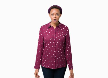 İzole arka plan üzerinde baş eşarp giyen güzel genç Afrikalı Amerikalı kadın sürpriz ifade, korku ve heyecanlı yüz ile şaşırdı ve şok.