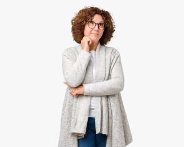 Beautiful middle ager senior woman wearing jacket and glasses over isolated background with hand on chin thinking about question, pensive expression. Smiling with thoughtful face. Doubt concept. clipart