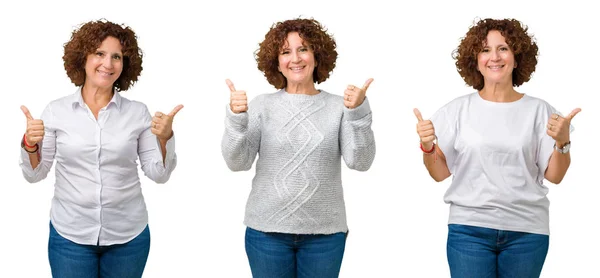 中年高级商务女性穿着白色T恤 在白色孤立的背景上做着积极的姿态 竖起大拇指微笑 看着相机欢快的表情 胜利者的手势 — 图库照片