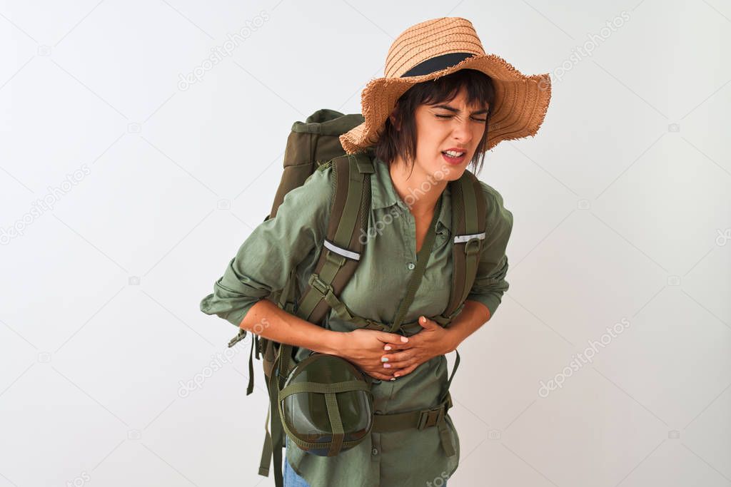 Hiker woman wearing backpack hat and water canteen over isolated white background with hand on stomach because indigestion, painful illness feeling unwell. Ache concept.
