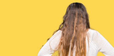 Geriye doğru uzakta silah ile vücut üzerinde seyir beyaz kazak ayakta giyen genç güzel kadın