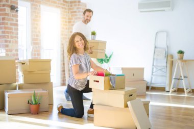 Orta yaş yaşlı çift yeni bir eve taşınıyor, gülümseyen kadın 