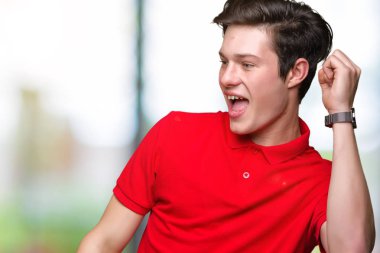 Hareketli rahat ve kendinden emin müzik gülümseyen mutlu ve neşeli, dans izole arka plan üzerinde kırmızı t-shirt giyen genç yakışıklı adam