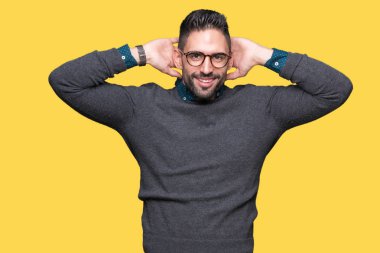 Genç yakışıklı adam gözlük izole üzerinde arka plan dinlenirken ve germe kollar ve eller baş ve boyun arkasında ile mutlu gülümseyerek