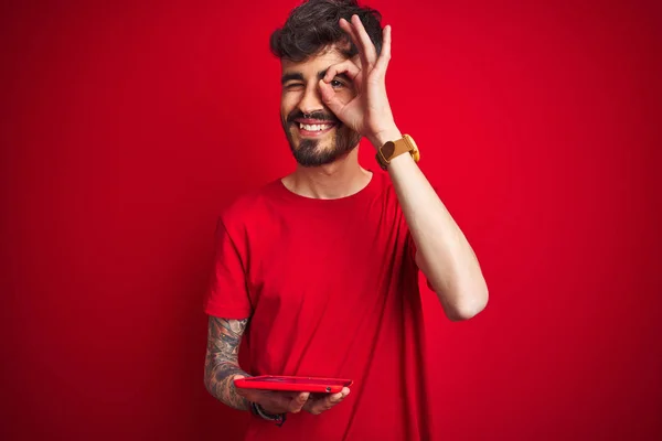 Young Man Tattoo Using Tablet Standing Isolated Red Background Happy — Stock Photo, Image