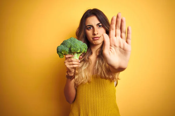 Ung Vacker Kvinna Äter Broccoli Över Gul Isolerad Bakgrund Med — Stockfoto