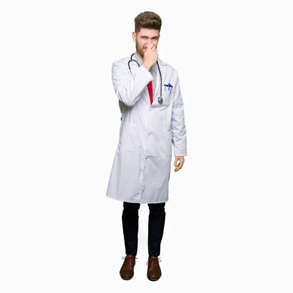 Joven Médico Guapo Que Usa Abrigo Médico Oliendo Algo Apestoso — Foto de Stock