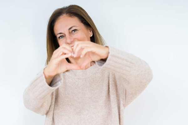 Красивая женщина средних лет на изолированном фоне улыбается в любви показывая символ сердца и форму с руками. Романтическая концепция
.