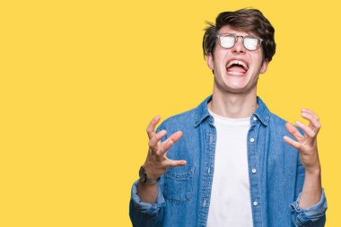 Üzerinde gözlük takan genç yakışıklı adam arka plan deli izole ve deli bağırarak ve agresif ifade ve silah kaldırdı bağırıyor. Hayal kırıklığı kavramı.