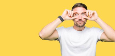 Yakışıklı adam rahat beyaz t-shirt giyen parmaklarıyla, uykulu ve sabah yorgunluk için yorgun gözlerini açmaya çalışıyor