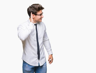 Bir işitme söylenti ya da dedikodu için dinleme kulak üzerinde el ile gülümseyen izole arka plan üzerinde gözlük takan genç iş adamı. Sağırlık kavramı.