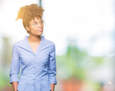 Güzel genç Afro-Amerikan iş kadını görünümlü yan ve dik dik bakma uzağa düşünce gülümseyen izole arka plan üzerinde.