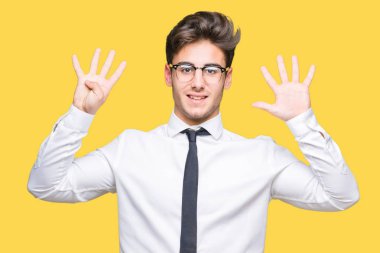 Gösterilen arka plan üzerinde gözlük takan genç iş adamı izole ve parmakları ile işaret numara 9 kendinden emin ve mutlu gülümseyerek süre.