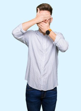 Yakışıklı delikanlı kapsayan gözler ve ağız el ile şaşırttı ve şok. Duygu gizleme