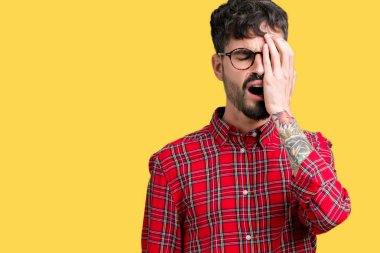 Yarım yüz, göz ve ağız el ile kapsayan yorgun esneme izole arka plan üzerinde gözlük takan yakışıklı delikanlı. Acı yüzü acıyor.