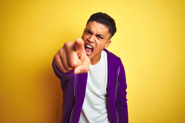 年轻的巴西男子穿着紫色运动衫站在孤立的黄色背景指向不满和沮丧的相机 愤怒和愤怒与你 — 图库照片