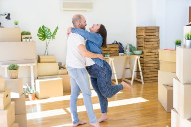 Genç çift yeni evde aşk civarı kartonlar kutuları sarılmak,