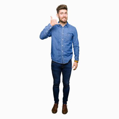 Casual kot gömlek gülümseyen giyen genç yakışıklı sarışın adam el ve parmak telefonda konuşmak ile telefon jest yapıyor. Kavramları iletişim.