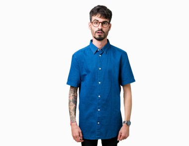 Korkuyor ve şok sürpriz ifade, korku ve heyecan yüz ile izole arka plan üzerinde gözlük takan genç yakışıklı adam.