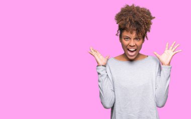 Güzel genç Afro-Amerikan kadın deli kutluyor ve silah ile başarı için heyecanlı çığlık kaldırdı ve açık gözleri hayret izole arka plan yüzünden. Kazanan kavramı