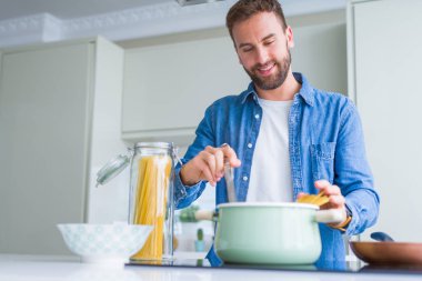 Evde makarna pişiren yakışıklı adam.
