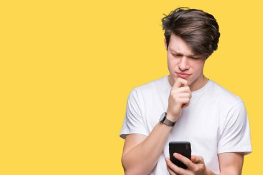 Genç adam izole arka plan üzerinde akıllı telefon kullanarak soru hakkında ciddi yüz düşünme, çok karışık fikir
