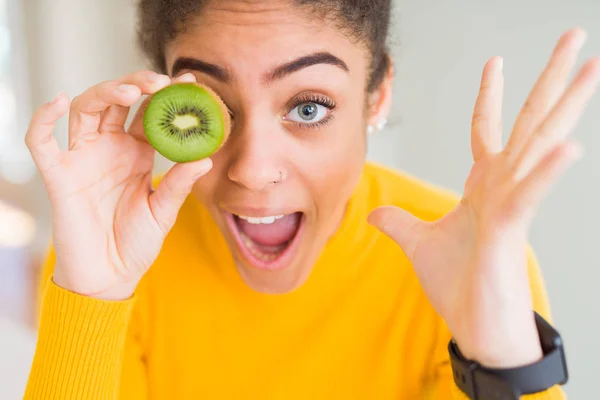 Ung Afrikansk Amerikansk Flicka Äter Grön Kiwi Mycket Glad Och — Stockfoto