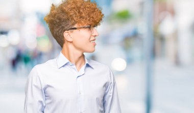Genç yakışıklı iş adamı ile uzak tarafına yüzünde, doğal ifade gülümseme ile seyir gözlüklü afro. Kendine güvenen gülüyor.