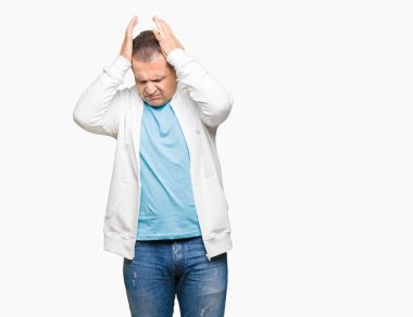 Orta yaş Arap adam baş ağrısı çaresiz ve stres nedeniyle ağrı ve migren ile izole arka plan üzerinde Sweatshirt giyiyor. Eller baş.