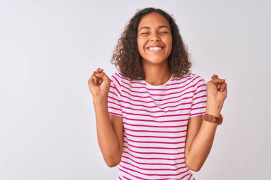 İzole beyaz arka plan gesturing parmak üzerinde duran pembe çizgili t-shirt giyen genç Brezilyalı kadın umut ve gözleri kapalı gülümseyerek geçti. Şans ve batıl kavram.