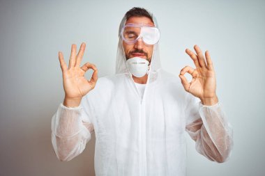 Izole arka plan üzerinde profesyonel işçi ekipman koruma giyen ressam adam dinlenmek ve parmakları ile meditasyon jest yapıyor kapalı gözleri ile gülümseyerek. Yoga konsepti.