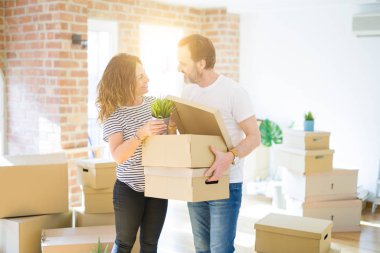 Orta yaş Senior çift yeni bir eve hareket, cardboar tutarak