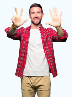 Yakışıklı adam rahat gömlek gösteren giyen ve parmak numarası sekiz ile işaret ederken emin ve mutlu gülümseyen.