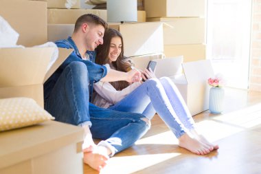 Karton etrafında yeni evin katında oturan genç çift 