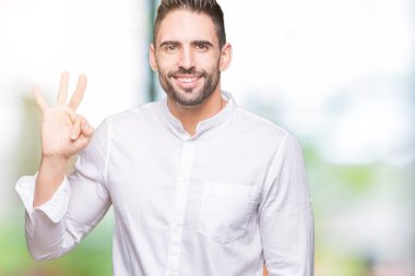 Genç iş adamı gösterilen ve parmakları ile işaret izole arka plan üzerinde üçüncü ise kendinden emin ve mutlu gülümseyerek.